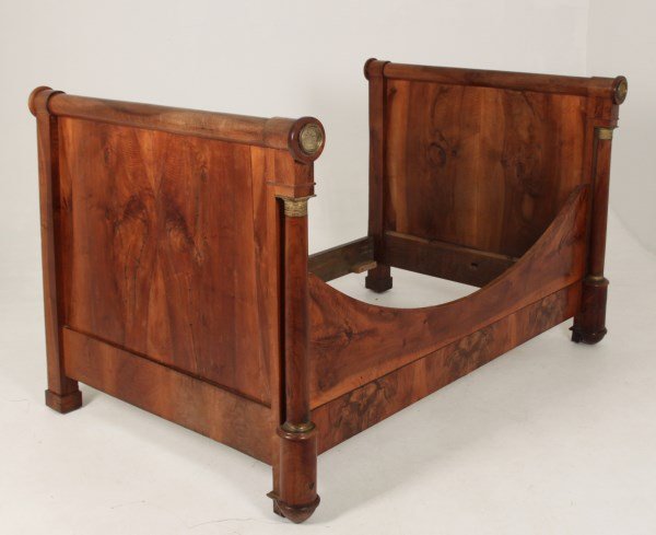 CROTCH MAHOGANY VENEERED FRENCH EMPIRE DAY BED: CROTCH MAHOGANY VENEERED FRENCH EMPIRE DAY BED HAVING TURNED COLUMN SUPPORTS WITH GILT BRONZE MOUNTS; 45"H X 77.5"W X 52"W; CONDITION: SHOWING MINOR WORMING THROUGHOUT, SOME SEPARATION IN WOOD ALSO