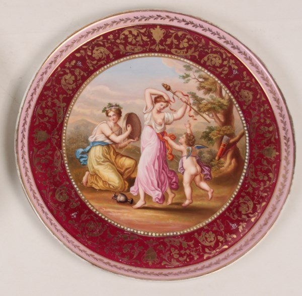 14.25" ROYAL VIENNA RIMMED CIRCULAR PLATTER: 14.25" ROYAL VIENNA RIMMED CIRCULAR PLATTER HAVING CENTER VIGNETTE OF CUPID WITH A PARTIALLY NUDE FEMALE FIGURE WITH KNEELING ATTENDANT PLAYING TIMBREL, MARKED ON THE REVERSE WITH BLUE BEEHIVE; 14.25"