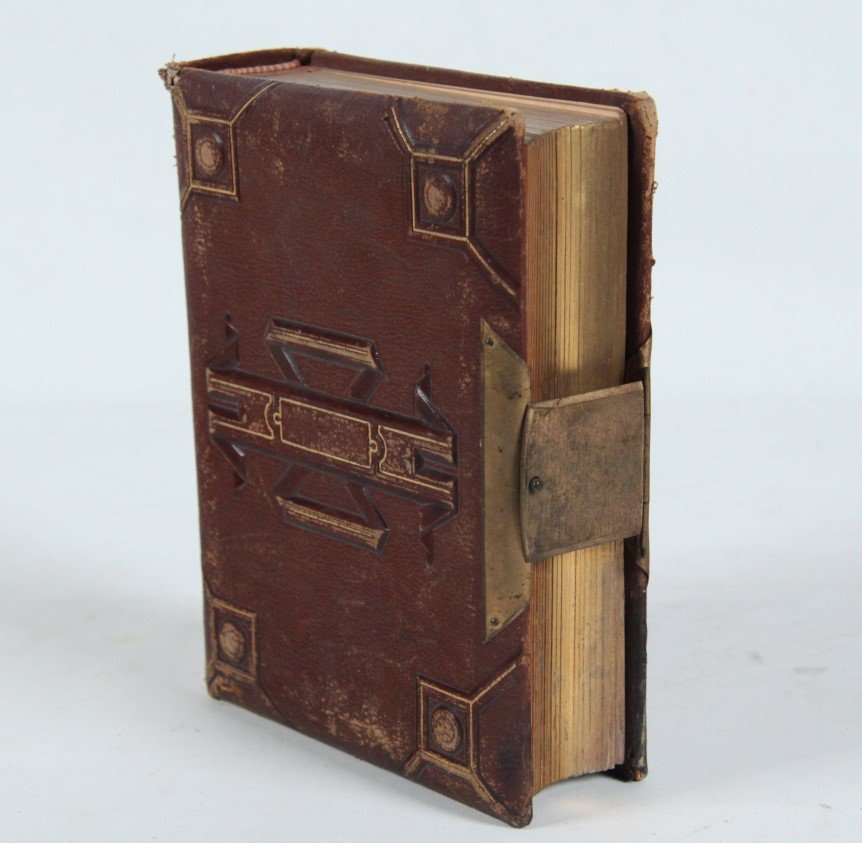 LEATHER AND BRASS BOUND PHOTO ALBUM WITH PORTRAIT: LEATHER AND BRASS BOUND PHOTO ALBUM CONTAINING VARIOUS PORTRAIT IMAGES INCLUDING CIVIL WAR SOLDIERS; 2.25"H X 6.5"W X 9"L; CONDITION: SCUFFING AND TEAR TO TOP EDGE OF BINDING