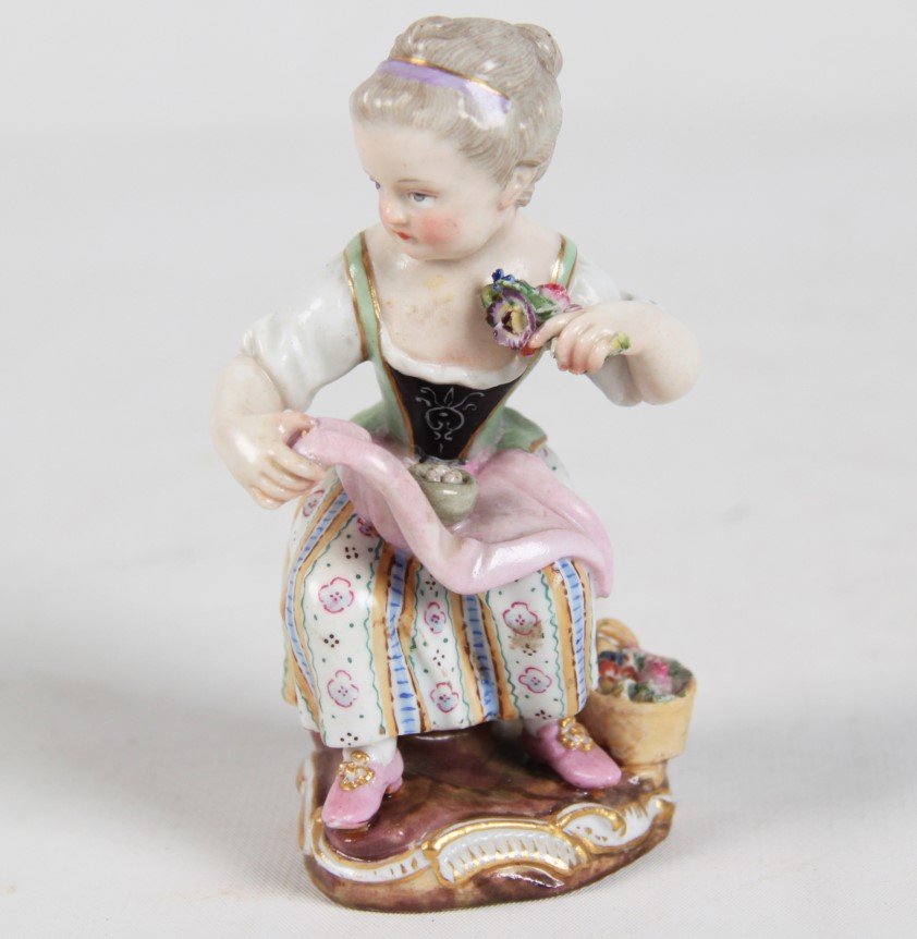 MEISSEN PORCELAIN FIGURE OF SEATED YOUNG GIRL: MEISSEN PORCELAIN FIGURE OF SEATED YOUNG GIRL HOLDING BOUQUET OF FLOWERS MARKED WITH BLUE CROSS SWORDS ON THE REVERSE; 4.25"H