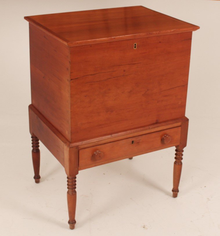 EARLY AMERICAN CHERRY SUGAR CHEST: EARLY AMERICAN CHERRY SUGAR CHEST HAVING EXPOSED DOVETAILING WITH HINGED TOP, LOCKING DIVIDED MAIN CAVITY OVER A RECTANGULAR DRAWER RESTING ON TURNED LEGS; 36"H X 26"W X 19.5"D; CONDITION: GOOD OVERAL