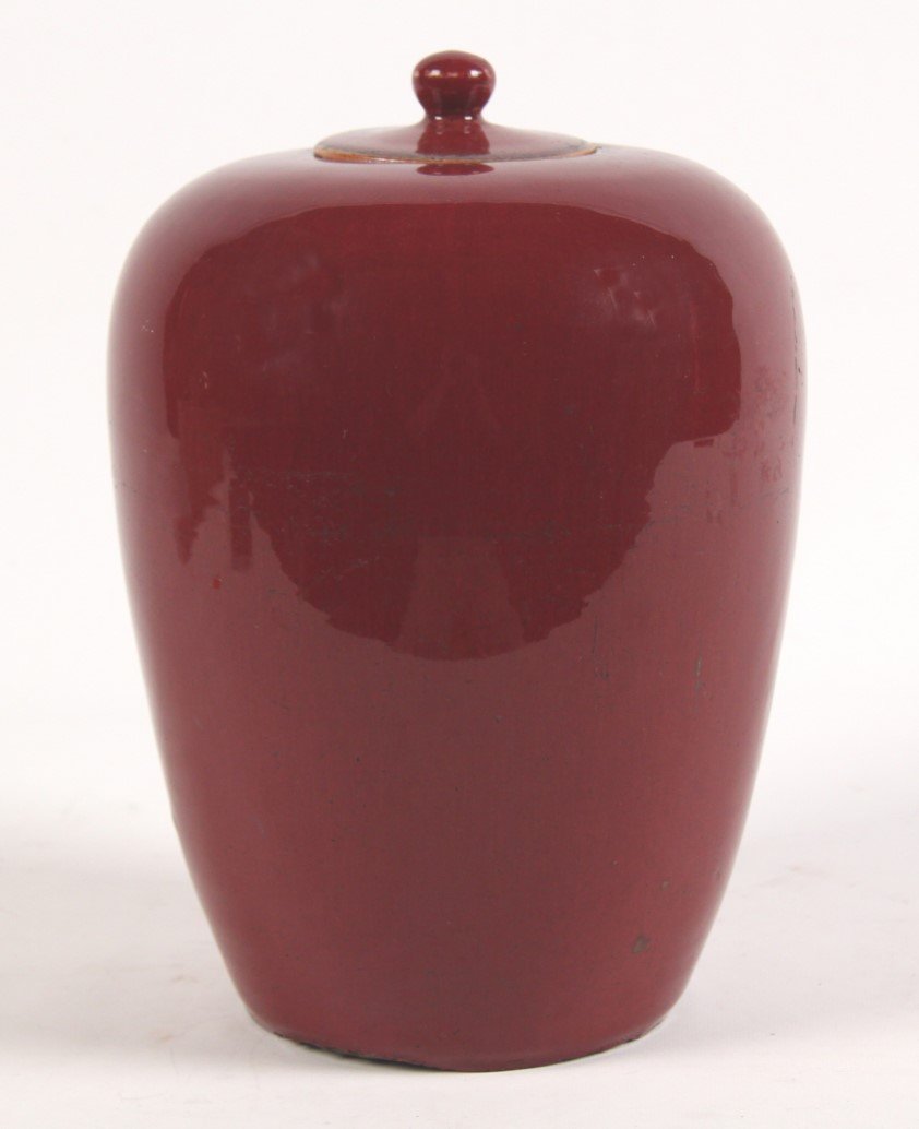 12" CHINESE PORCELAIN OX-BLOOD TAPERD CAPPED JAR: 12" CHINESE PORCELAIN OX-BLOOD TAPERD CAPPED JAR; 12"H; CONDITION: UNEVENESS AND CHIP TO BOTTOM APPEARS TO BE ORIGINAL AND CONSISTENT WITH AGE