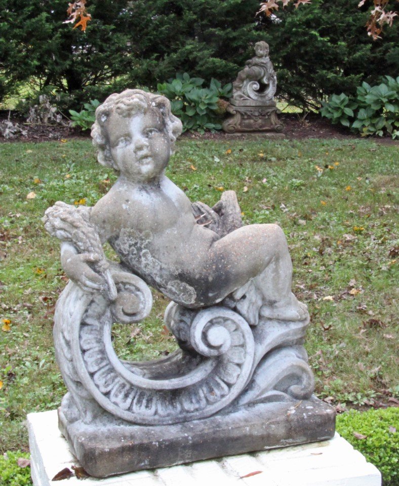 PAIR OF ITALIAN STYLE CAST STONE PUTTI ON "C" SCROLL: PAIR OF ITALIAN STYLE CAST STONE PUTTI ON "C" SCROLL PLINTH; 30"H X 22"W X 12"D