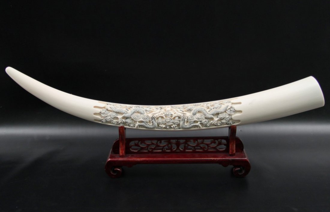 ORIENTAL DRAGON CARVED IVORY TUSK: ORIENTAL DRAGON CARVED IVORY TUSK ON OPEN WORK HARDWOOD STAND; 10.5"H X 30"W X 2.5"D OVERALL; NOTE: There is no International shipping allowed on this lot, domestic USA sale only. Bidders should check