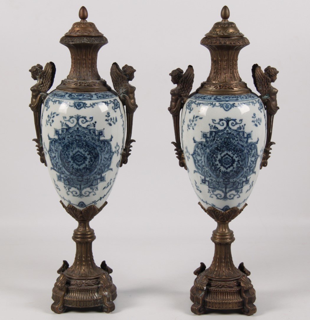 PAIR OF FRENCH STYLE PORCELAIN CAPPED URNS: PAIR OF DECORATIVE FRENCH STYLE BLUE AND WHITE BRONZE MOUNTED PORCELAIN CAPPED URNS HAVING NUDE WINGED FIGURAL MOUNTS; 23"H