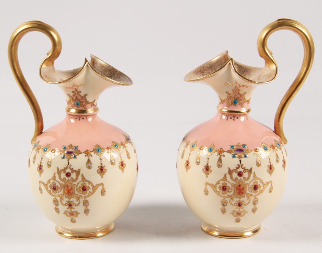 PAIR OF ENGLISH COALPORT CABINET EWERS: PAIR OF ENGLISH COALPORT CABINET EWERS HAVING A GOLD NECKLACE AND ENAMEL JEWELED DECORATED WAIST ON A YELLOW, CREAM, AND SALMON GROUND HAVING TRI-FORMED SPOUT WITH HANDLE; 8.25"H X 4"W