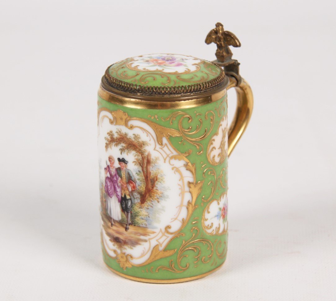 19TH C. PETITE ROYAL VIENNA HINGED TANKARD: PETITE ROYAL VIENNA HINGED TANKARD WITH GILT EAGLE SURMOUNT HAVING GREEN ENAMEL AND RAISED GOLD FIELD WITH FLORAL AND CENTER COURTING SCENE VIGNETTE, MARKED WITH BLUE BEEHIVE UNDERGLAZE ON REVERSE, 19