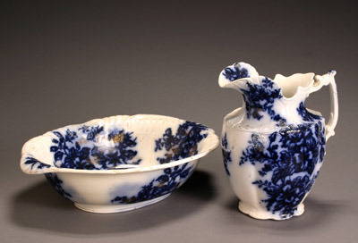 Flow Blue 'Azalia' Pitcher and Basin Probably by Jam: Flow Blue 'Azalia' Pitcher and Basin Probably by James Kent Chip to rim of pitcher and basin. Height of pitcher: 12-1/2 in; Diameter of basin: 19-1/2 in
