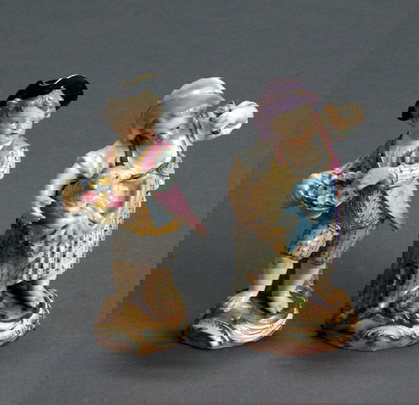 Two Meissen Figures of a Girl with Lamb and a Boy: Two Meissen Figures of a Girl with Lamb and a Boy with Flowers 1860-1924 Each dressed in a pink flowered coat and raised on a terrain-painted and rocaille-molded base. Each with underglaze blue crosse