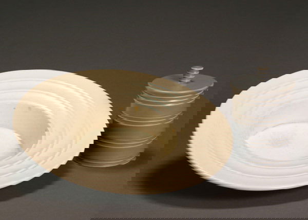 Two Keith Murray Wedgwood Table Articles After 194: Two Keith Murray Wedgwood Table Articles After 1940 The first, a moonstone shallow bowl, having a wide rim with incised banding; the second, a gray glazed covered jar with ribbed bandings. The first w