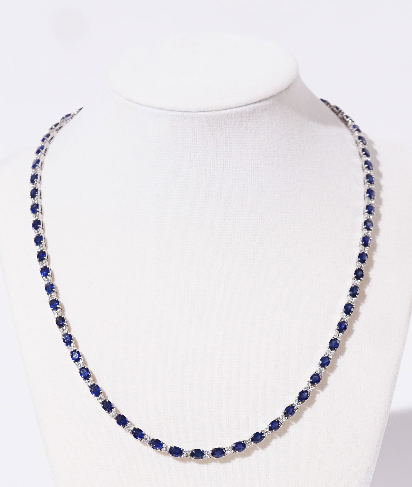 18-Karat White-Gold, Blue Sapphire and Diamond Necklace, Gross weight: 16.4 dwt., Length: 18 in: 18-Karat White-Gold, Blue Sapphire and Diamond NecklaceSet with sixty-five oval faceted blue sapphires weighing approximately 22.75 carats, alternating with approximately two hundred sixty round brill