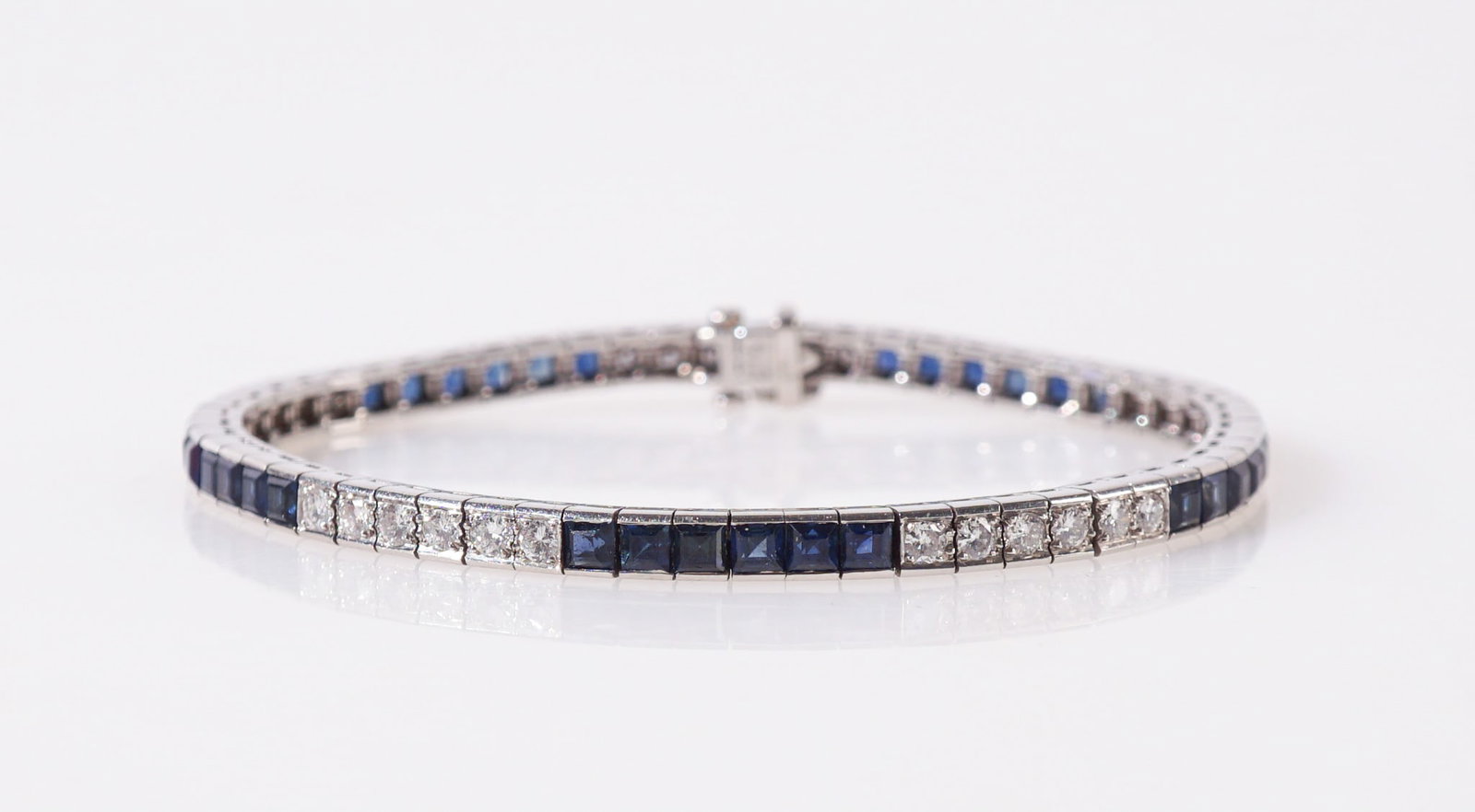 Waslikoff & Sons Platinum, Blue Sapphire and Diamond Line Bracelet, Gross weight: 15.6 dwt., Length:: Waslikoff & Sons Platinum, Blue Sapphire and Diamond Line Bracelet Set with thirty square-cut blue sapphires weighing approximately 4.50 carats and thirty round brilliant-cut diamonds weighing approxi