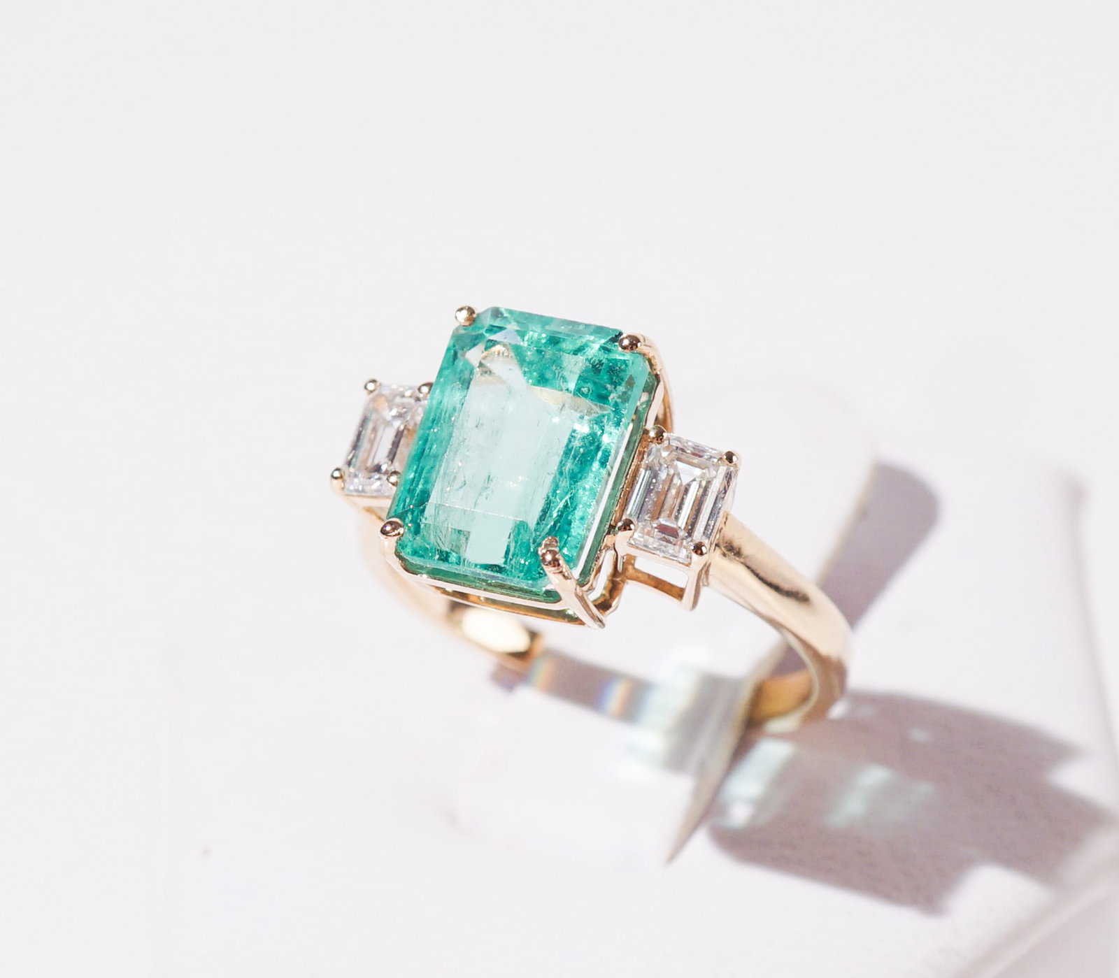 18-Karat Yellow-Gold, Colombian Emerald and Diamond Ring, Shank size: 6-1/4: 18-Karat Yellow-Gold, Colombian Emerald and Diamond Ring Centered with one octagonal-cut emerald weighing 3.44 carats, flanked by two emerald-cut diamonds weighing .60 carats.The emerald accompanied b