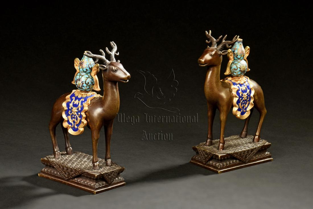 PAIR OF BRONZE CAST 'DEER' INCENSE BURNERS: The pair of bronze incense burners shaped in the form of deer, each carrying a cloisonne enameled double gourd vase on its back, standing on delicate stand. Height: 7 1/2 in (19.1 cm) Length: 5 1/2 in