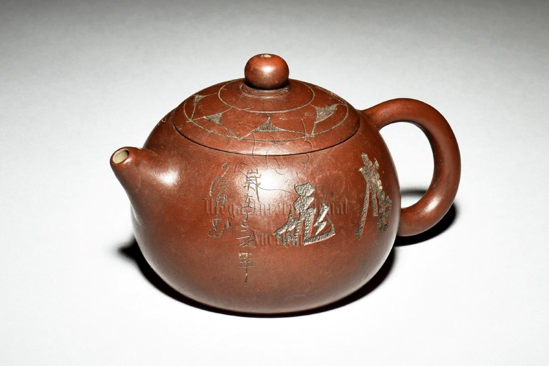 YIXING ZISHA 'EAGLE' TEAPOT: The Yixing Zisha teapot is of expanding bulbous form with short spout and C shaped handle, body incised with flying eagle and poetry calligraphy, complete with domed lid and bead finial, clay is of br