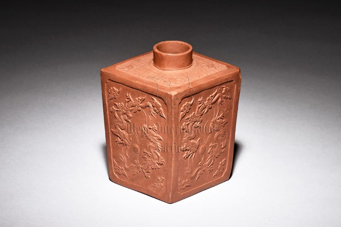 YIXING ZISHA STONEWARE RECTANGULAR 'DRAGONS' JAR: The Yixing Zisha jar is of rectangular form, exterior depicts flying dragons chasing after flaming pearl amidst clouds, bottom bears four character mark. Height: 4 1/4 in (10.8 cm) Length: 2 7/8 in (7