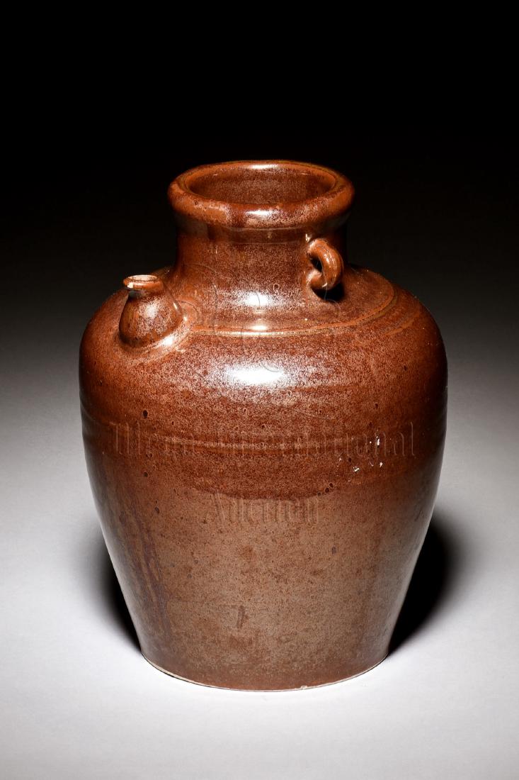 BROWN GLAZED EWER WITH HANDLES: The ewer is of bulbous form, with small and short spout stemming from the shoulder, two tiny handles mounted on the neck, glazed overall in rich brown color tone, bottom unglazed. Height: 9 in (22.9 c