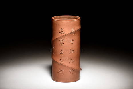 YIXING ZISHA BEMBOO SECTION BRUSH POT: The brush pot in the design of slanted bamboo sections, the exterior incised with Chinese poetry calligraphy, artist signature 'Shi Mei'. Height: 9 1/4 in (23.5 cm) Width: 4 1/4 in (10.8 cm) 紫&