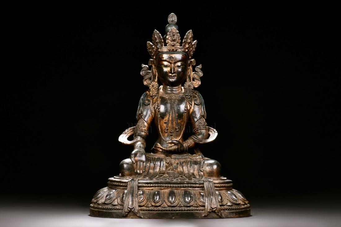 RED COPPER AND SPLASH GILT SEATED GUANYIN FIGURE: The Guanyin seated in dhyanasana on top of lotus throne pad, one hand in dhyana mudra, and the other hand palms up against the lap, eyes open in serene expression, the exterior splash gilt against the