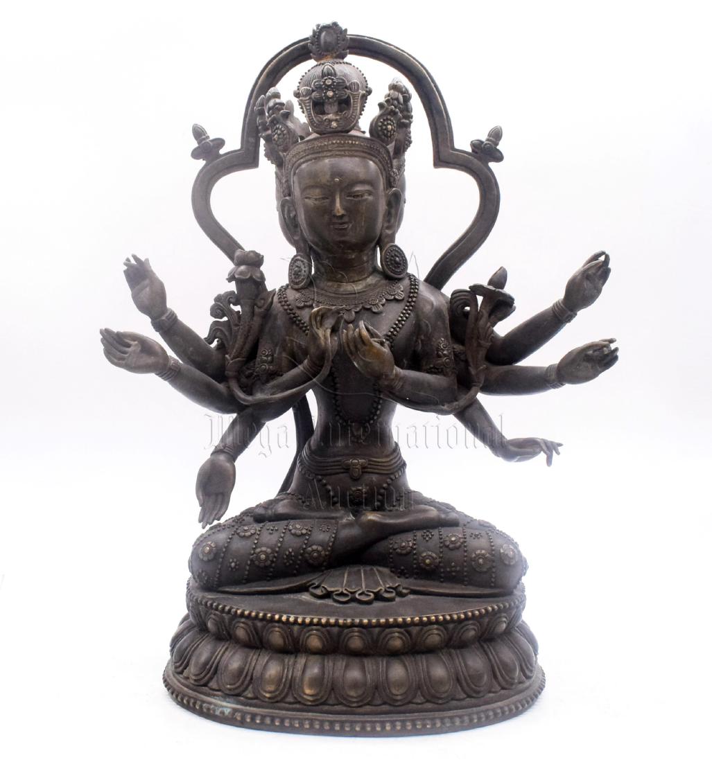 BRONZE CAST EIGHT-ARM AVALOKITESHVARA SEATED FIGURE: The bronze cast Avalokiteshvara seated on top of double lotus throne pad in dhyanasana, eight hands raised in various mudra, with lotus flowers stem from her arms, wearing ornate robe with crown, each