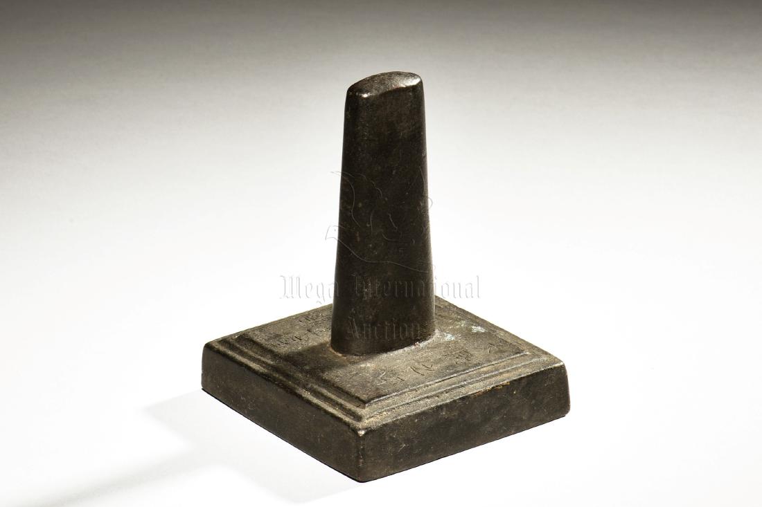 IRON CAST GENERAL'S SEAL: The iron cast stamp seal is of compressed square form with a tall cylindrical knob at top, incised with date and General's Seal in Chinese, bottom bears four character mark. Height: 4 1/2 in (11.4 cm)