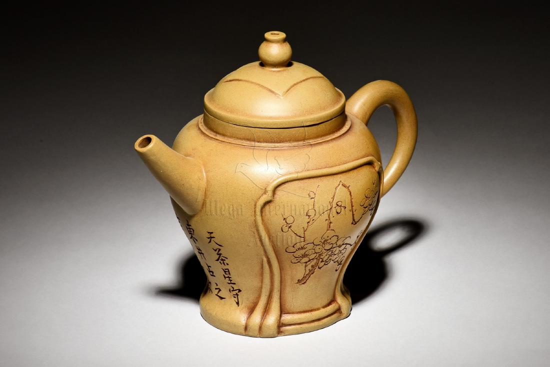 YIXING ZISHA OPEN MEDALLION TEAPOT: The Yixing Zisha stoneware teapot is of baluster form, on one side of the body depicts flower blossom within medallion, the other side with landscape scenery within medallion, the clay is of light bro