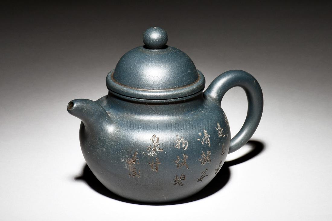 YIXING ZISHA 'BAMBOO AND CALLIGRAPHY' TEAPOT: The Yixing Zisha stoneware teapot is of bulbous form, on one side of the body depicts bamboo grove, the other side with calligraphy , the clay is of dark blue color tone, and the teapot has a total of