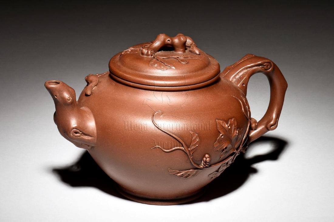 YIXING ZISHA 'GRAPES' TEAPOT: The Yixing Zisha stoneware teapot is of bulbous form, on one side of the body depicts grapes, vines, and squirrel, the other side with similar motif, the clay is of brown color tone, and the teapot ha