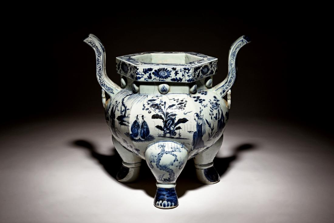 LARGE BLUE AND WHITE 'EIGHT IMMORTALS' TRIPOD CENSER: The large blue and white censer lobed in six sections on the exterior, stands on three beast hoof legs, body depicts Eight Immortals in forest setting engaged in various activities, below two raised h