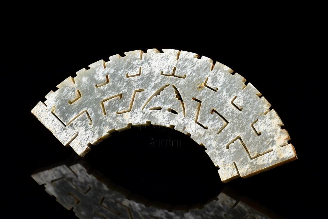JADE OPENWORK CARVED 'DRAGON' ORNAMENT, HUANG: The jade huang ornament carved in the form of a flattened bridge, body openwork carved with dragon and angular patterns, the jade is of chicken-bone white and russet color tone with slight translucenc