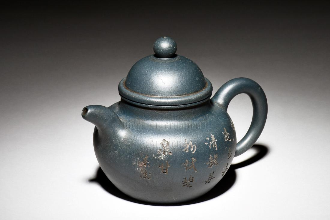 YIXING ZISHA 'BAMBOO AND CALLIGRAPHY' TEAPOT: The Yixing Zisha stoneware teapot is of bulbous form, on one side of the body depicts bamboo grove, the other side with calligraphy , the clay is of dark blue color tone, and the teapot has a total of