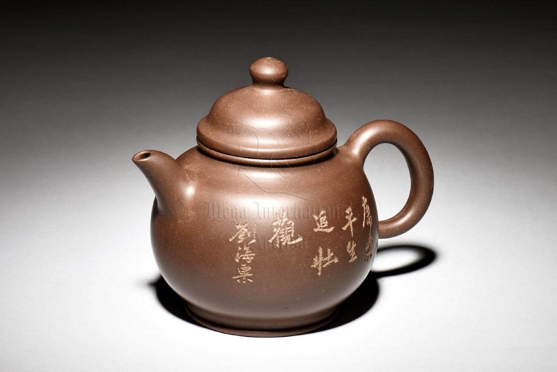 YIXING ZISHA 'CALLIGRAPHY' TEAPOT: The Yixing Zisha stoneware teapot is of bulbous form, the body incised with poetry calligraphy, with domed lid and bead finial on top, the clay is of dark brown color tone, and the teapot has a total
