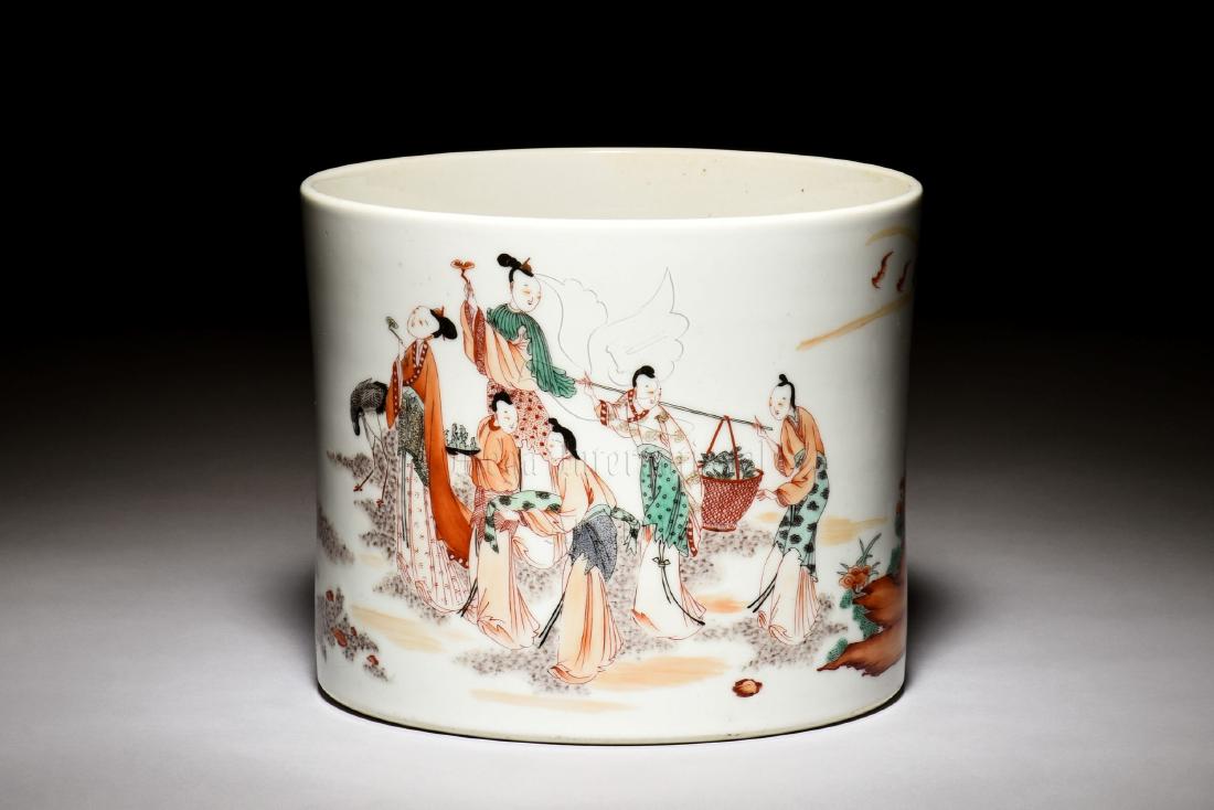 FAMILLE ROSE 'LADIES' BRUSH POT: The famille rose brush pot is of cylindrical form, depicts many celestial ladies walking amidst clouds with auspicious items in hands, bottom bears six character KANGXI reign mark. Height: 6 1/2 in(15