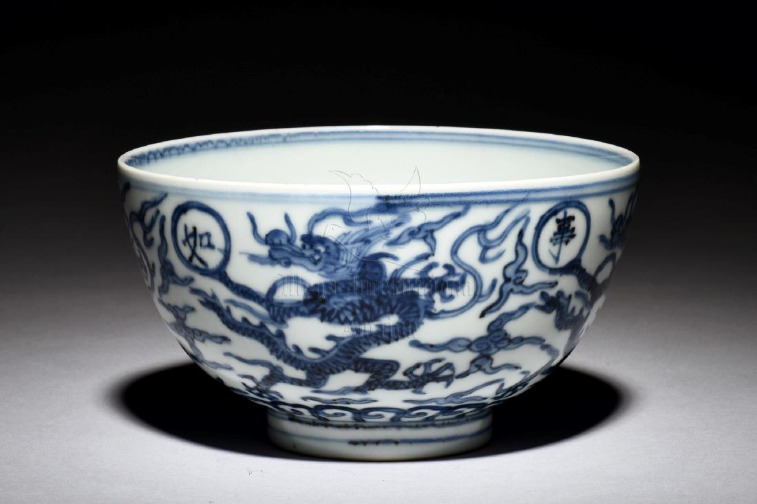 BLUE AND WHITE 'DRAGON' BOWL: The blue and white bowl depicts flying dragons amidst clouds and above lappet band, interior bears same motif, bottom bears six character WANLI reign mark. Height: 3 1/8 in (7.9 cm) Diameter: 5 1/2 in