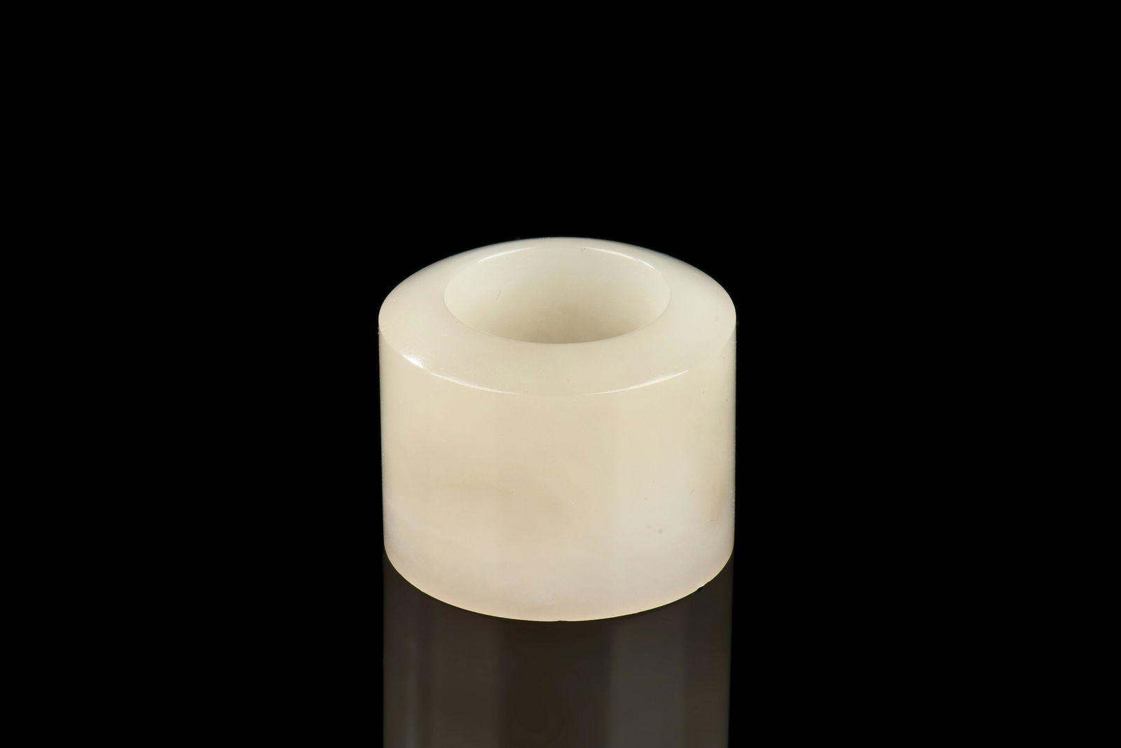 JADE THUMB RING: 玉扳指 The jade thumb ring is of rounded cylindrical form, carved smoothly on the edges, the jade is of greyish-celadon color tone with mottled interior and slight translucency. Jade