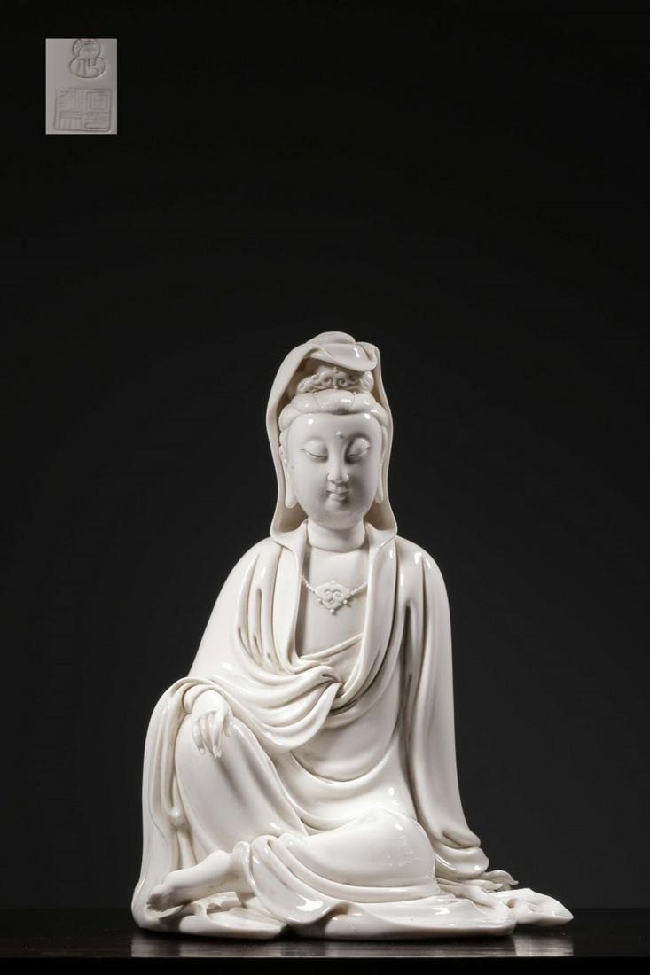 DEHUA BLANC DE CHINE WHITE GLAZED AND CARVED 'GUANYIN' SEATED FIGURE: 清“何朝宗”款德化白瓷观音坐像 Dehua blanc de chine white glazed and carved 'Guanyin' seated figure Height: 12 3