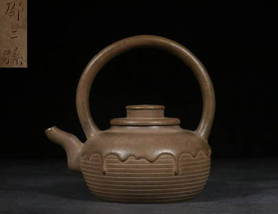 YIXING ZISHA BROWN CLAY CARVED 'RING PATTERNS' ROUNDED TEAPOT WITH LIFTING HANDLE: “邵二孙”款手工制旋纹提梁紫砂壶 Yixing Zisha brown clay carved 'Ring Patterns' rounded teapot with