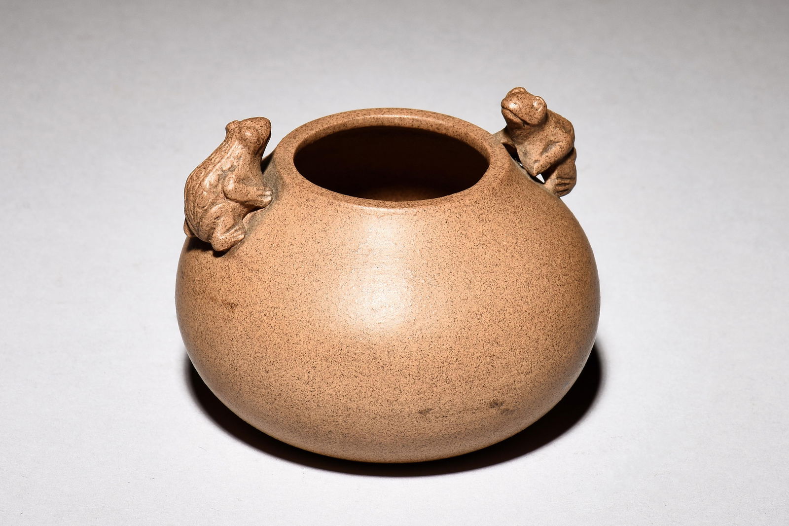YIXING ZISHA 'FROGS' JAR: 紫砂小罐 The Yixing Zisha jar is of globular form, the top mounted with two frogs acting as handles, the clay is of light brown color tone, bottom bears two character mark. Yix