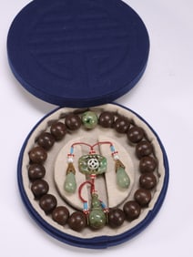 AGARWOOD DECORATED WITH JADE SPACER BEADS AND 18 CHILDREN HOLDING ROSARY BEADS