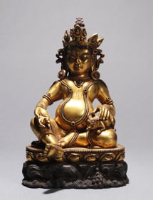 A GILT-BRONZE FIGURE OF JAMBHALA