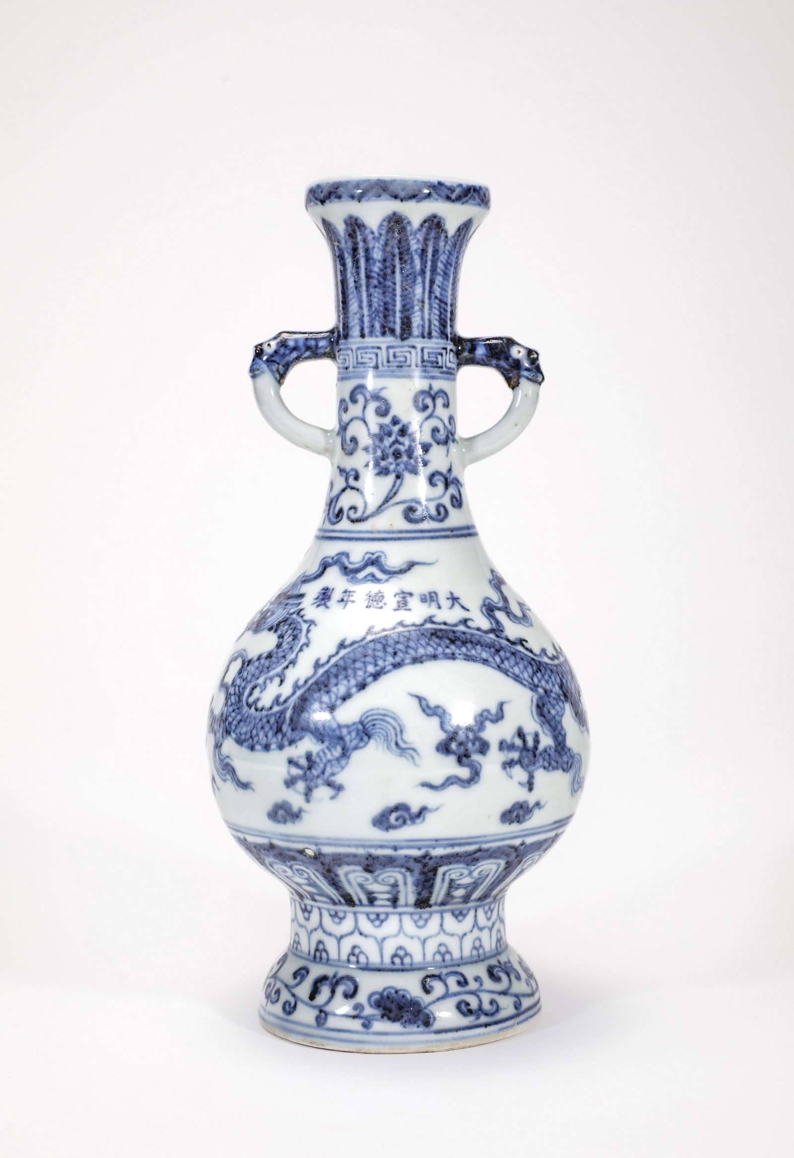 A BLUE AND WHITE DRAGON VASE: 明宣德青花云龙纹双耳盘口瓶 A blue and white dragon vase Ht.25cm