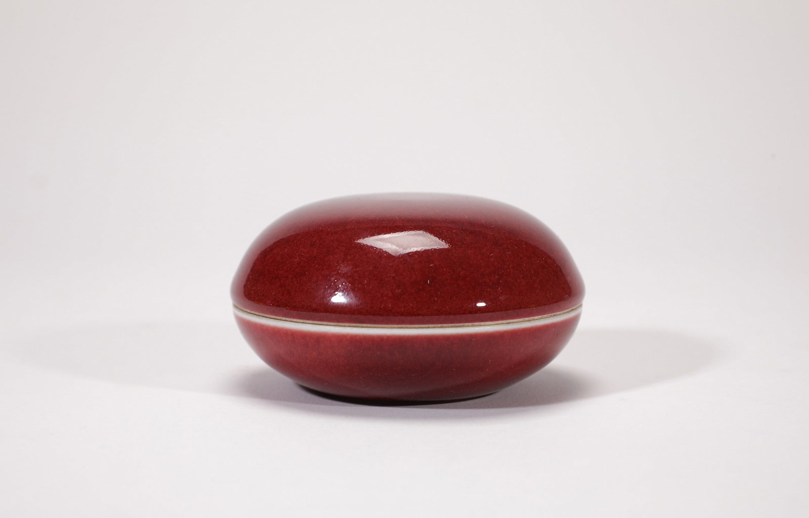 A RED GLAZED BOX: 清康熙红釉胭脂盒 A red glazed box 7.5X4CM