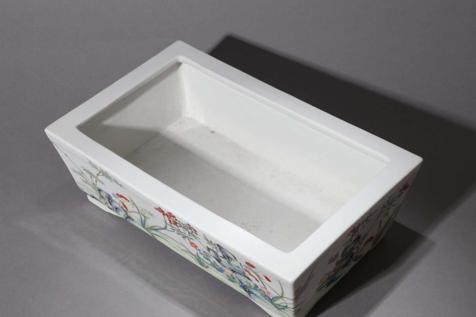 A FAMILLE-ROSE FLOWER POT: 民国 粉彩山石花卉水仙盆 A famille-rose flower pot 30x19x10cm