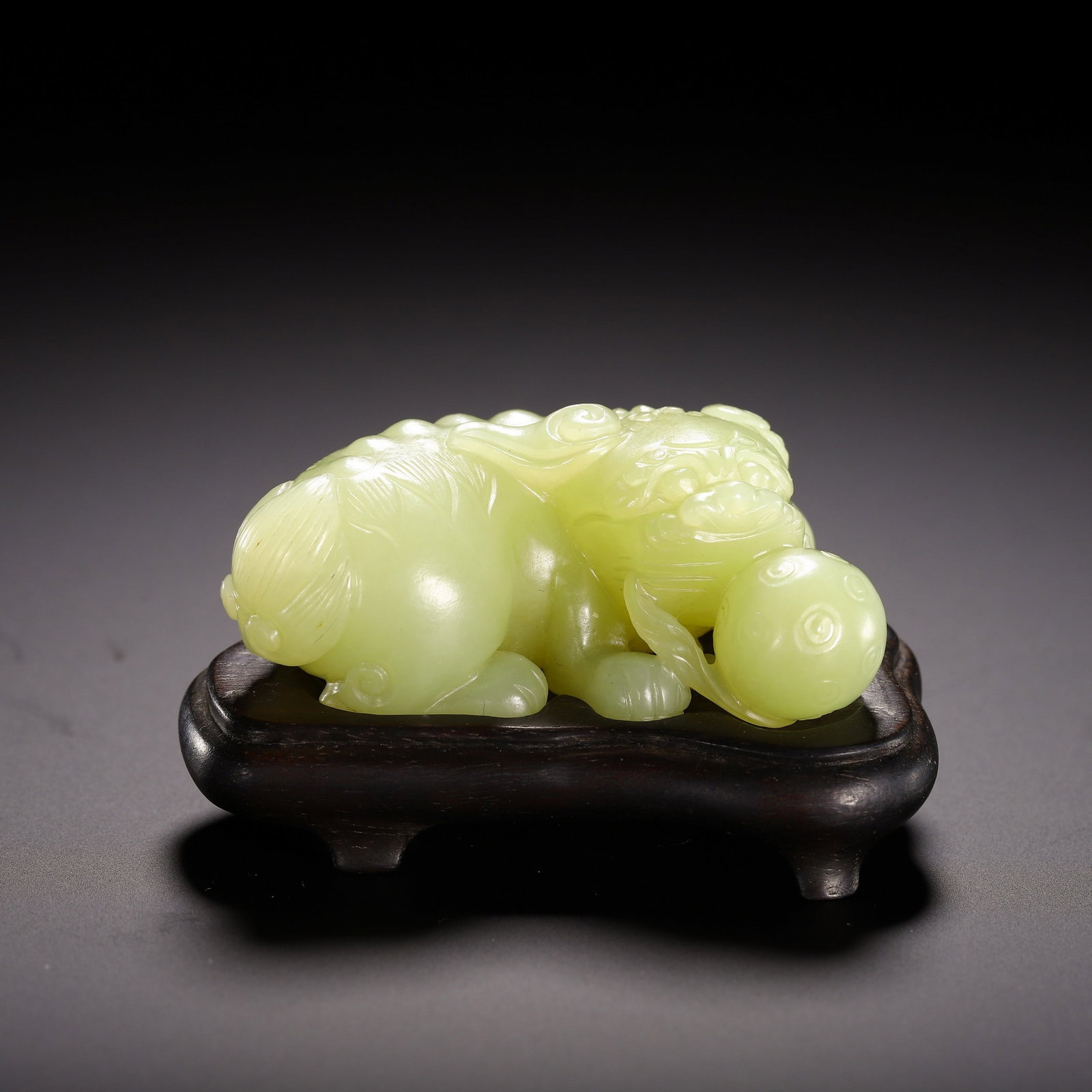 A JADE LION: 黄玉狮子滚绣球摆件 A jade lion Lg.6.5cm