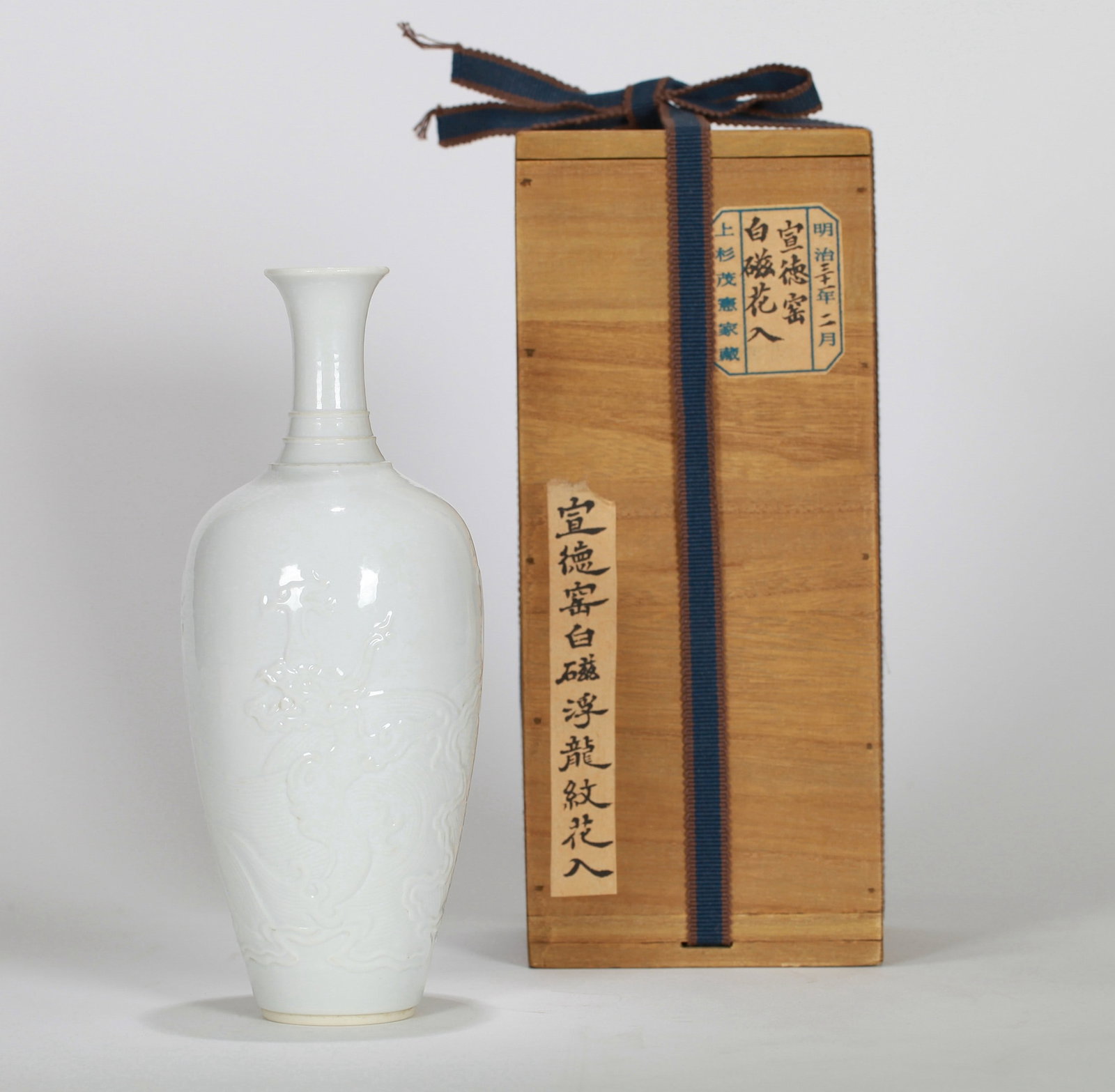 A WHITE GLAZED DRAGON VASE: 清 白釉刻龙纹瓶 A white glazed dragon vase Ht.21cm