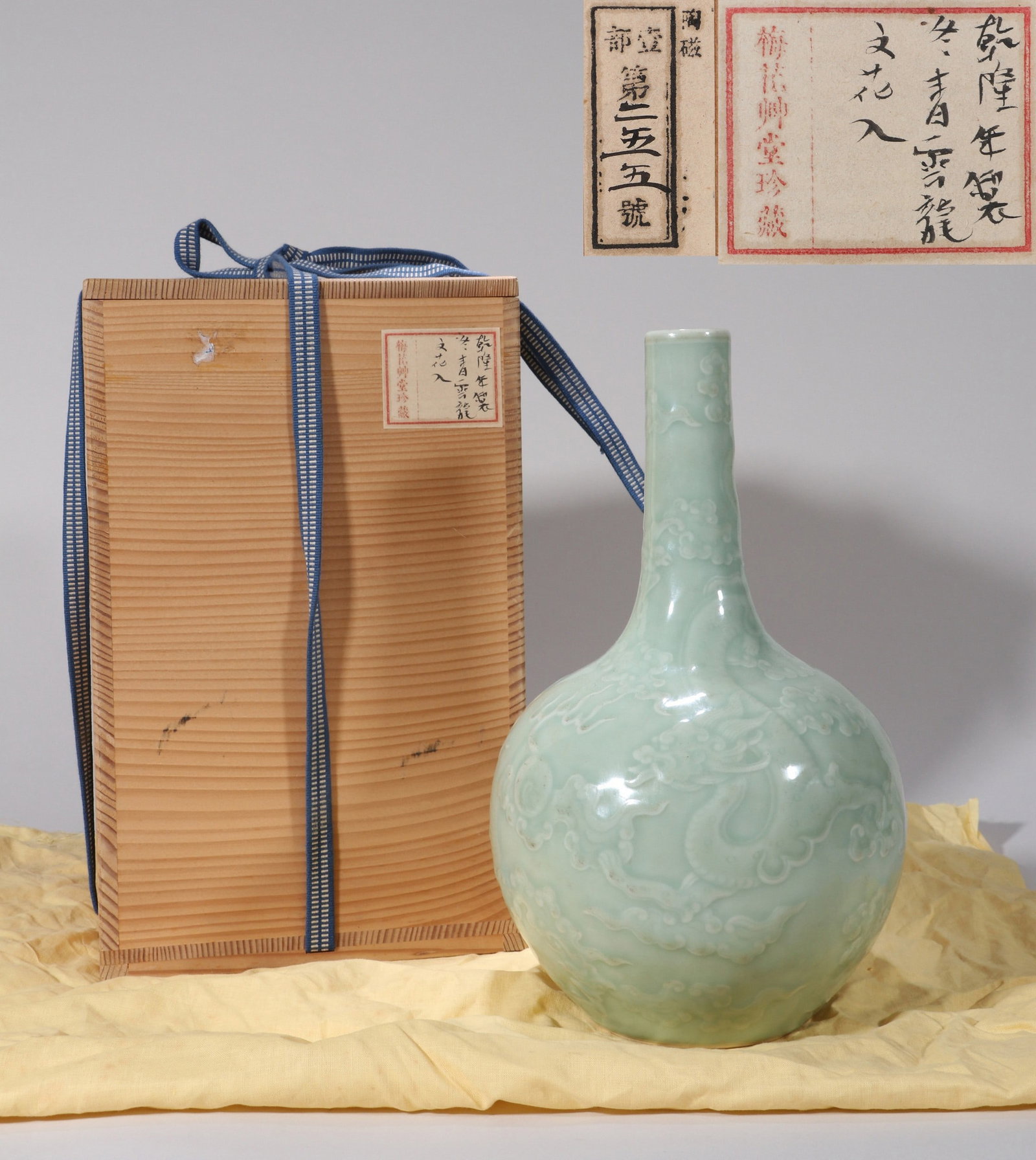 A CELADON-GLAZED DRAGON NECK VASE: 清乾隆 豆青模印云龙纹长颈瓶 A celadon-glazed dragon neck vase Ht.27cm