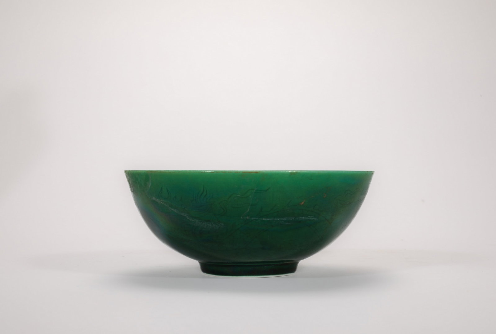 A GREEN-GLAZED DRAGON BOWL: 明成化绿釉暗刻龙纹碗 A green-glazed dragon bowl Diam.12cm Ht.5cm