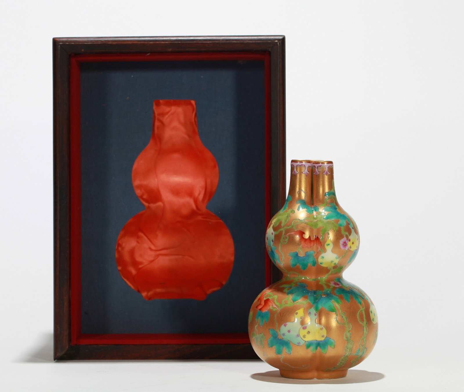 A GOLD GROUND FAMILLE-ROSE FLORAL DOUBLE-GOURD VASE: 清乾隆 金地粉彩三孔葫芦瓶 （附木盒） A gold ground famille-rose floral double-gourd vase H15.5cm