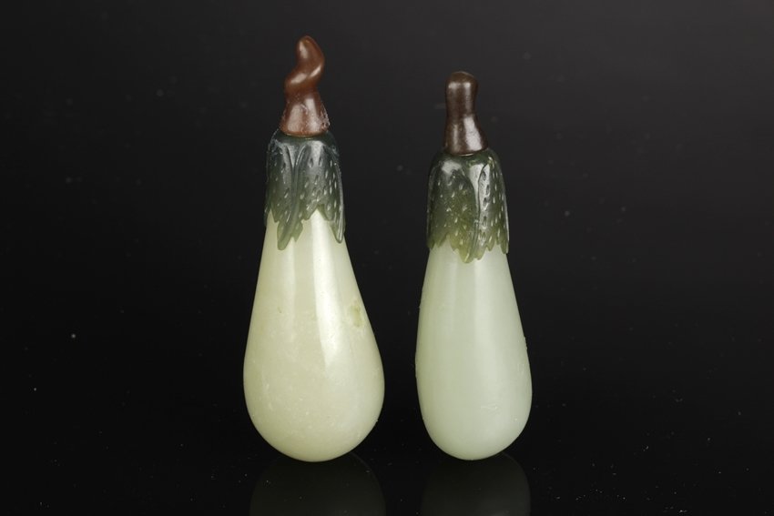 A PAIR OF CARVED GLASS EGGPLANT-SHAPED SNUFF BOTTLES: Each glass carved snuff bottle is of eggplant shape and is finely hollowed. It has short and bulbous light green body with leafy foliage surrounded on top, and capped by a brown peduncle shaped stoppe