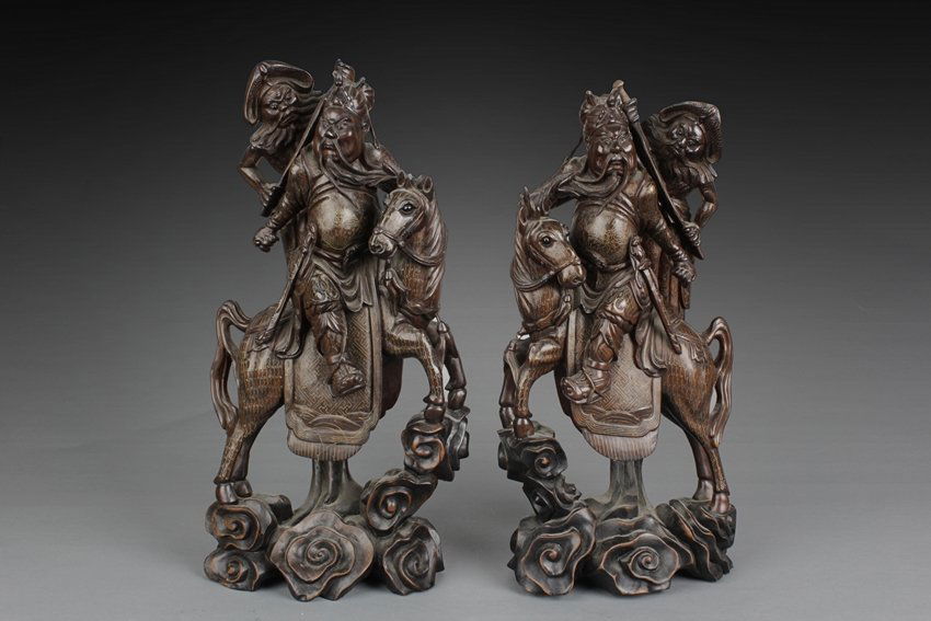 TWO HARDWOOD 'GUANGONG' CARVINGS W/SILVER LINES INSET: Each figure depicts Guan Yu, wearing armor with cloth on top, is mounted on a horse on top of clouds, while Zhou Cang in the form of a bearded man with a machete is shown standing on the clouds behind